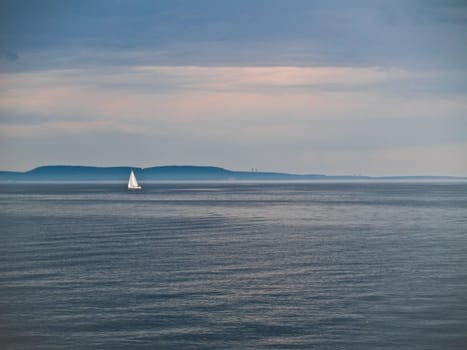 Duotone shot of sailboat on sea.