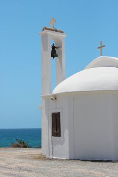 White church with catholic cross over blue sky
