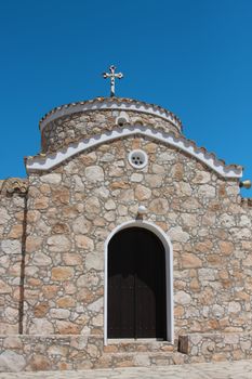 Greek church with cros over blue sky