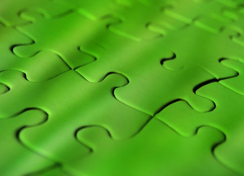 Green coloured jigsaw puzzle with plain pieces