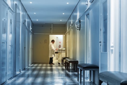 Doctor working at the end of a hospital hall