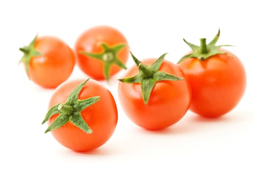 few fresh ripe tomatoes cherry over white. Shallow DOF