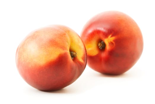 two fresh ripe peaches over white. Shallow DOF