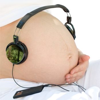 Headphones on a pregnant woman's abdomen