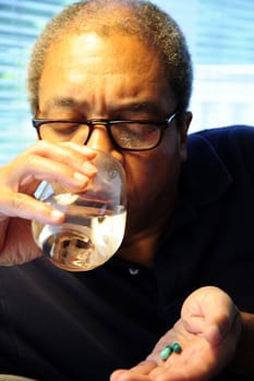 African american man taking his medicine.