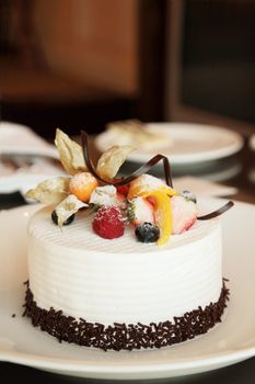 White Cream Icing Cake with Fruits and Chocolate