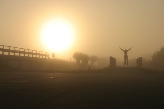 morning jump on the bicycle bridge by a foggy field