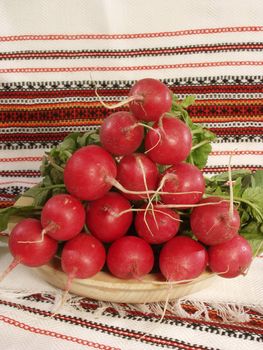 Garden radish on a wooden plate with the Ukrainian national towels    