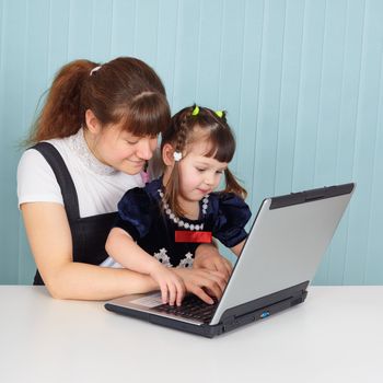 Mom teaches daughter to use a computer