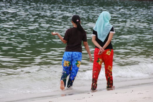 Two friends walking along a beach