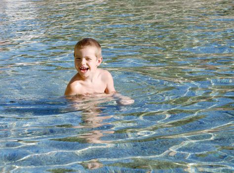 a boy is smiling and playing in a water