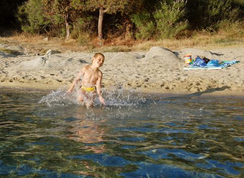 a boy is smiling and playing in a water