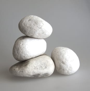 Four big white stones over gray background