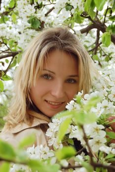 beautiful woman among blooming cherry tree