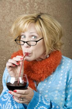 Funny woman drinking wine through a straw
