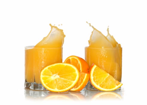 Two glasses of splashing orange juice and oranges isolated with clipping path on white background