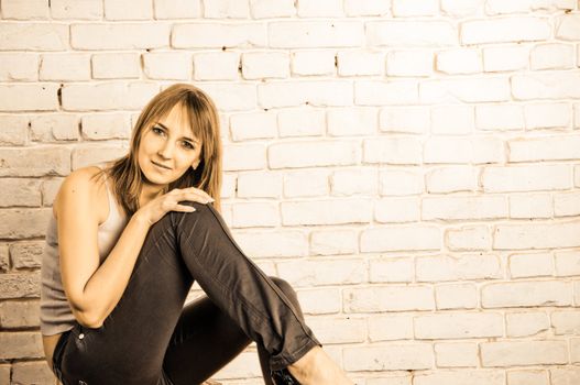 Beautiful blond woman on brick wall