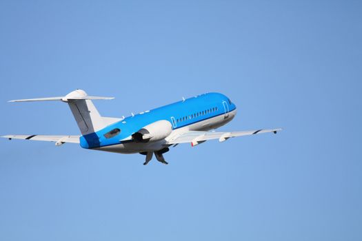 A two engine aircraft departing in a clear blue sky