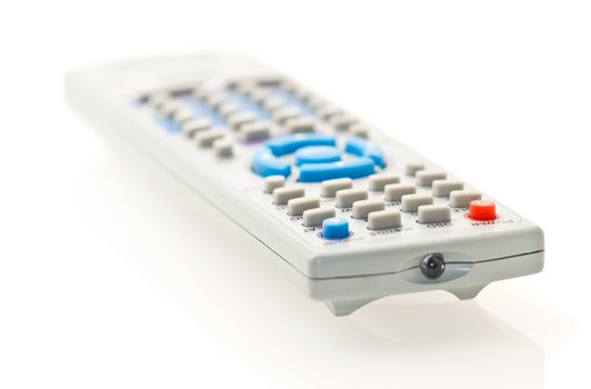 grey remote control for TV over white. Shallow DOF.