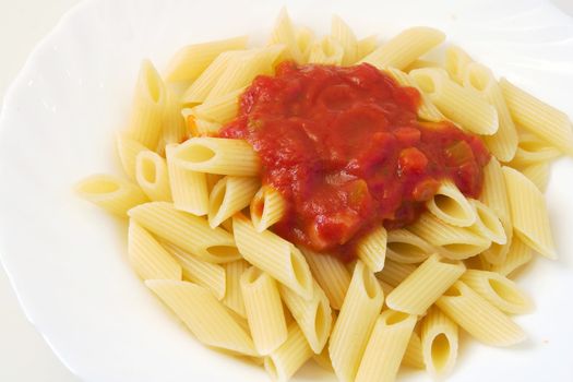 typical dish of italian cooking: penne with tomato sauce isolated on white background