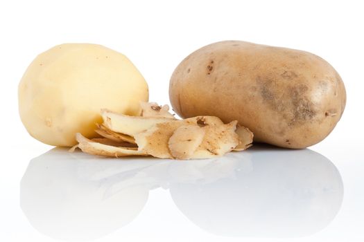 two potatoes with skins are reflected on white background