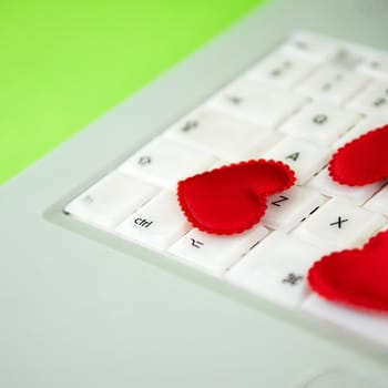 red quilted love hearts on white laptop keyboard