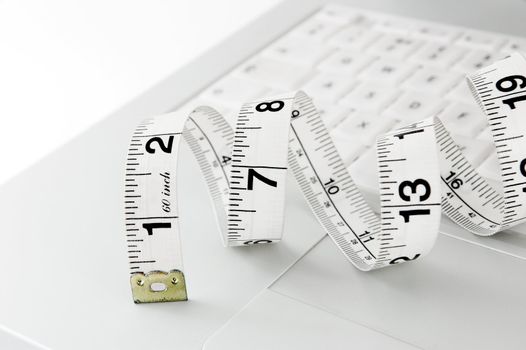 measuring tape on laptop keyboard