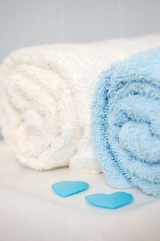 Rolled bathroom towels, sitting on toilet with blue scattered hearts