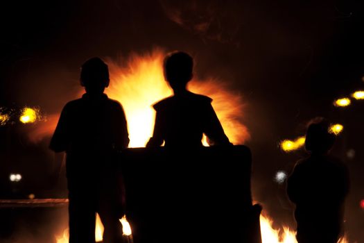 Children building a fire on Halloween evening set in silhouette