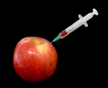 Red apple with a syringe on a black background