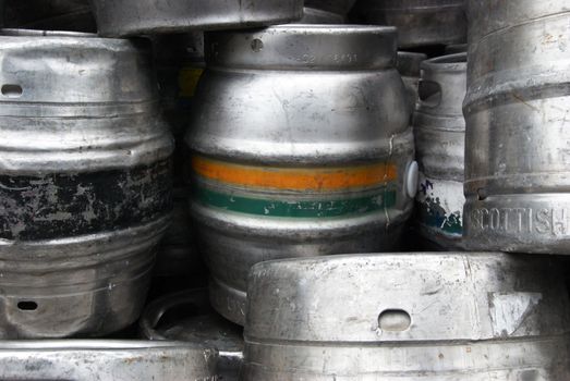 beer barrels stacked on the the pavement in front of a bar