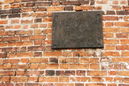 The ancient metal tablet on a stone wall