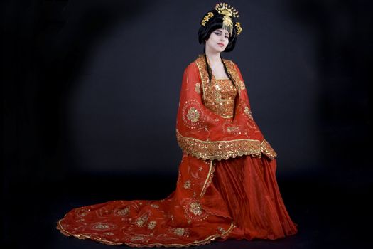 Portrait of an elegant asian princess dressed in golden and red with a crown. 