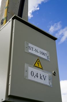 Fuse box with black/yellow sign warning for risk of electrocution