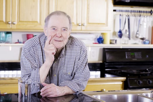 Elderly man leaning on counter