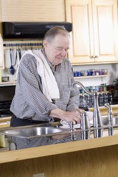 Elderly man washing dishes