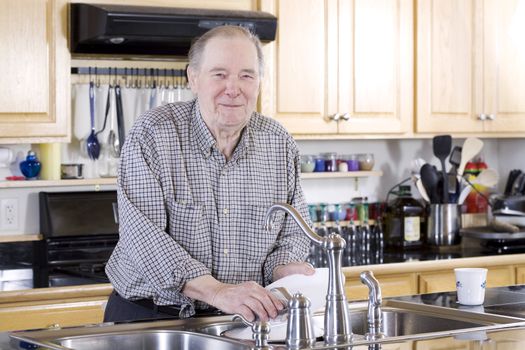 Elderly man washing dishes