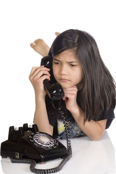 Girl talking on rotary phone, worried expression