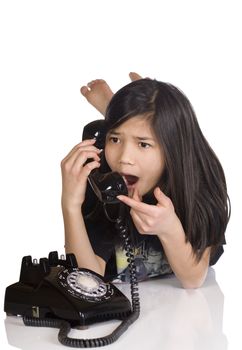 Girl talking on rotary phone, shocked expression