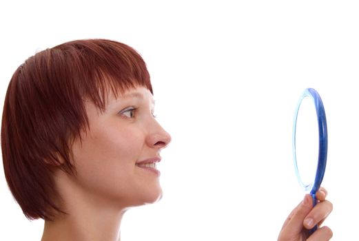 Portrait of red-haired girl with a mirror in a high key.