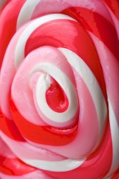 Close up image of a red, pink, and white swirly lollipop