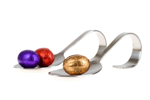 two appetizer spoons with colorful chocolate eggs