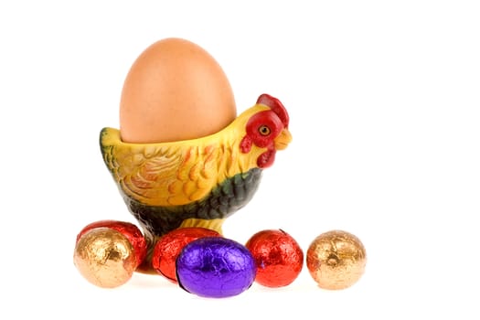 an egg in a egg cup with chocolate eggs