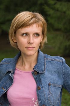 Young cute woman in a denim jacket looking at something