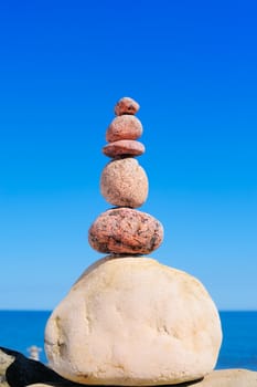 A pile of the round pebbles on background the blue sky