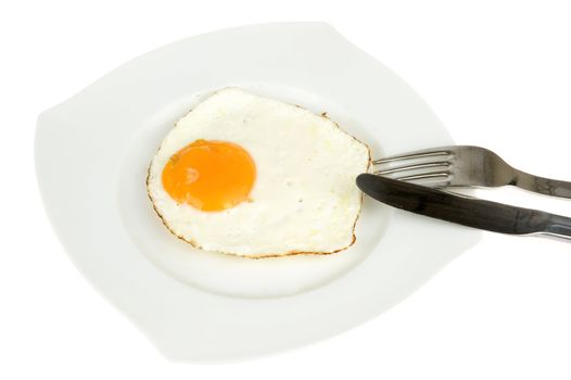 a fried egg on a plate with a fork and knife