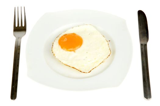 a plate with a fried egg, a fork and a knive