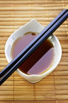 Close up of chopsticks on white soy sauce dish