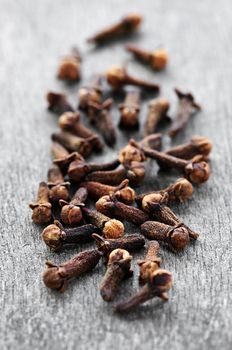 Several dried clove buds on wooden background