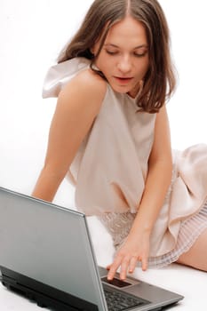 Portrait of a happy young female using a laptop over white background